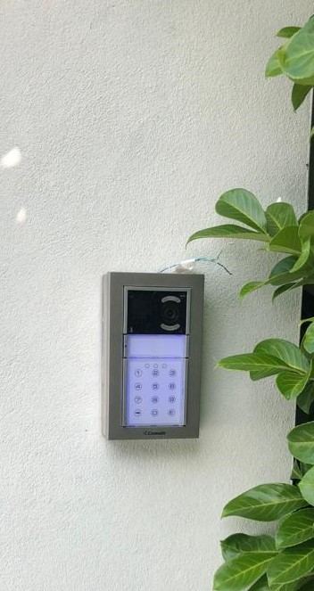 Video door entry and alarm keypad panel installed beside a front entrance